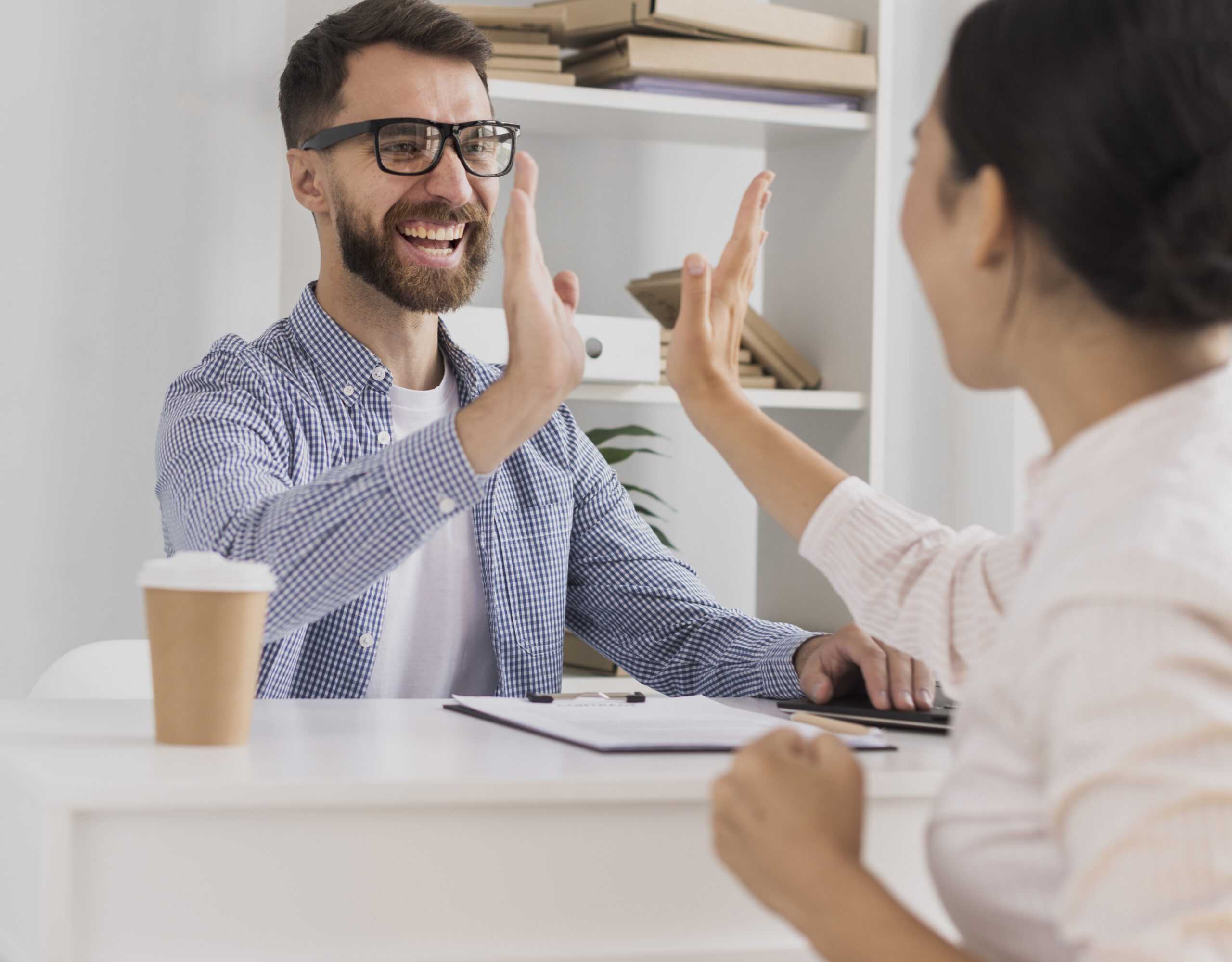 happy coworkers celebrating with high five scaled